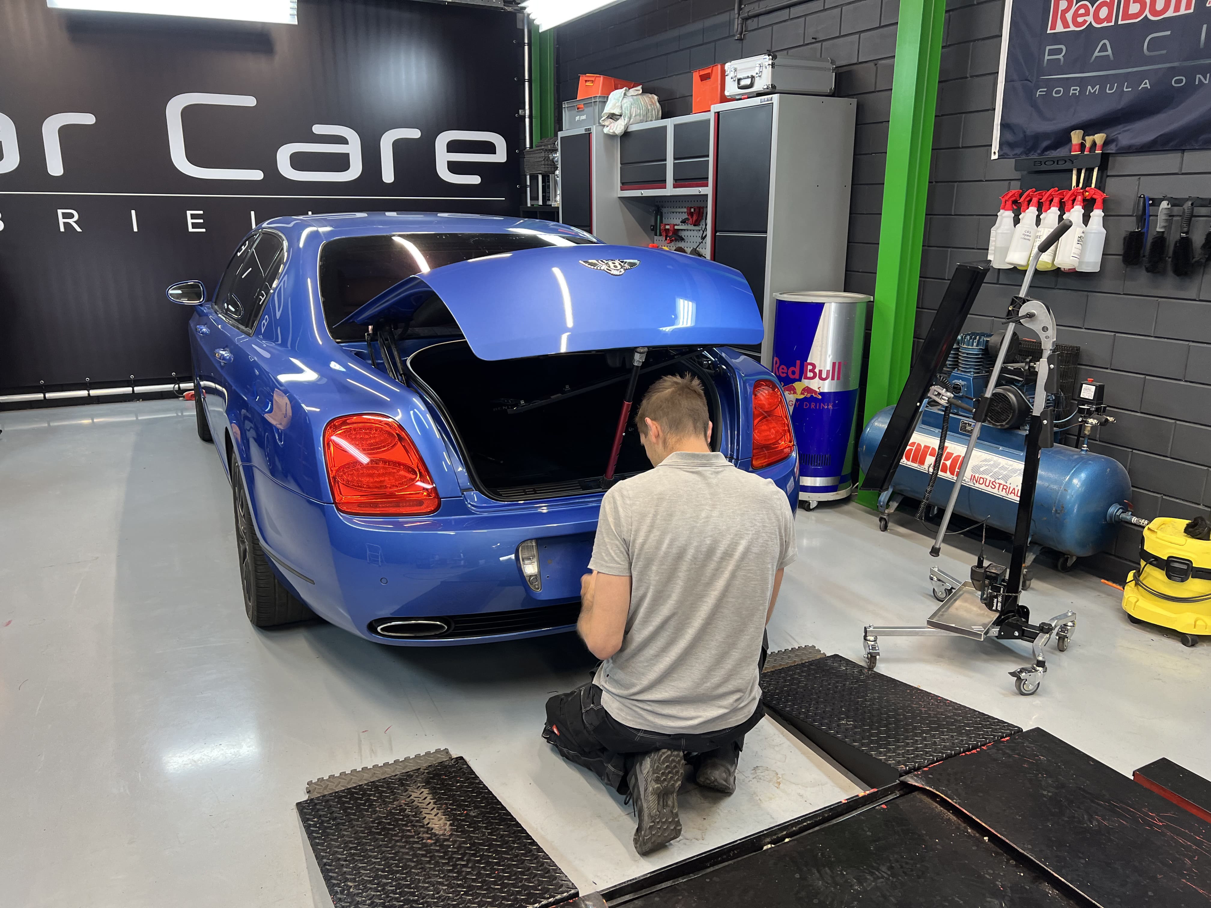 Medewerker van Car Care Brielle werkt aan auto